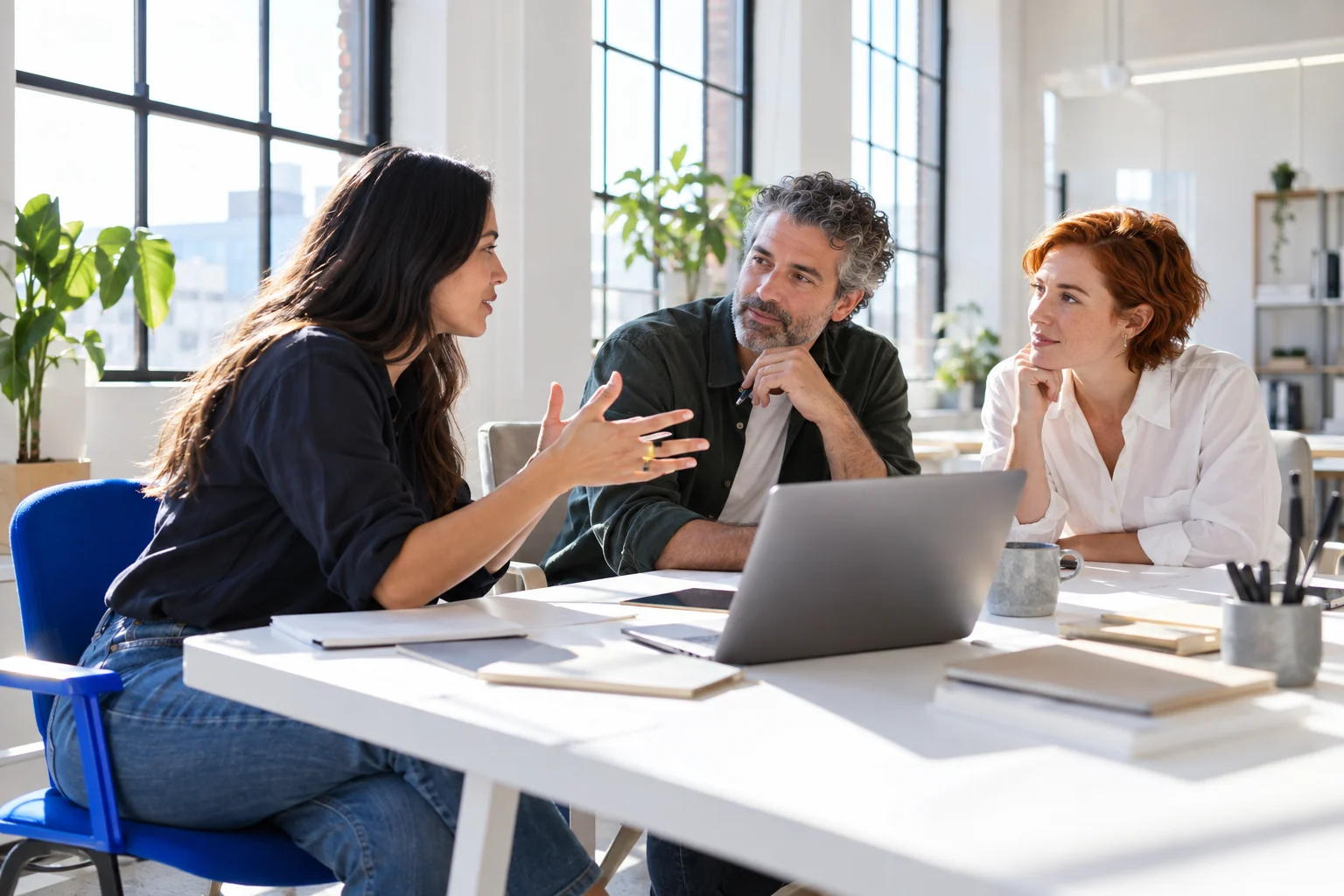Business colleagues sharing ideas around a contemporary meeting table