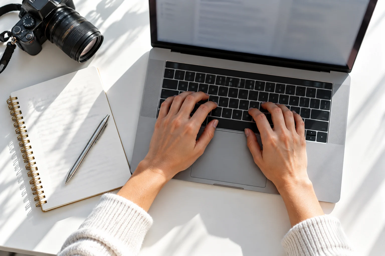 A content workspace with a keyboard, notebook, pen, and camera